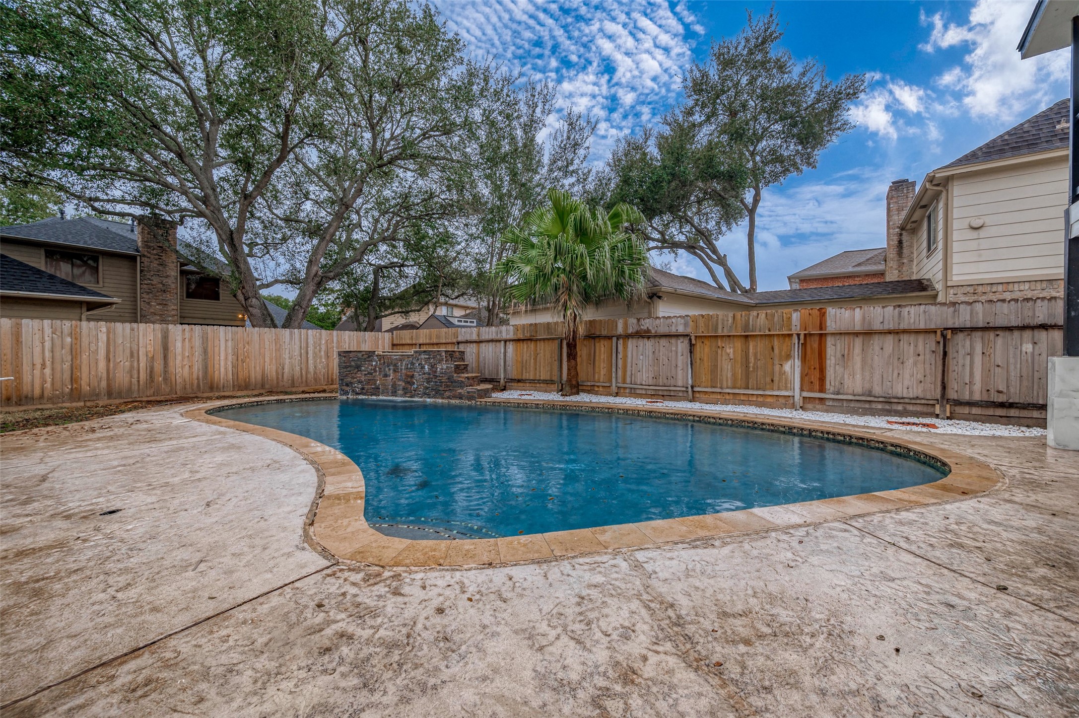 919 Mockingbird Way Sugar Land, TX 77478 - Photo 38 of 41 Elegant stone patio, and mature trees, all enclosed by a wooden privacy fence.