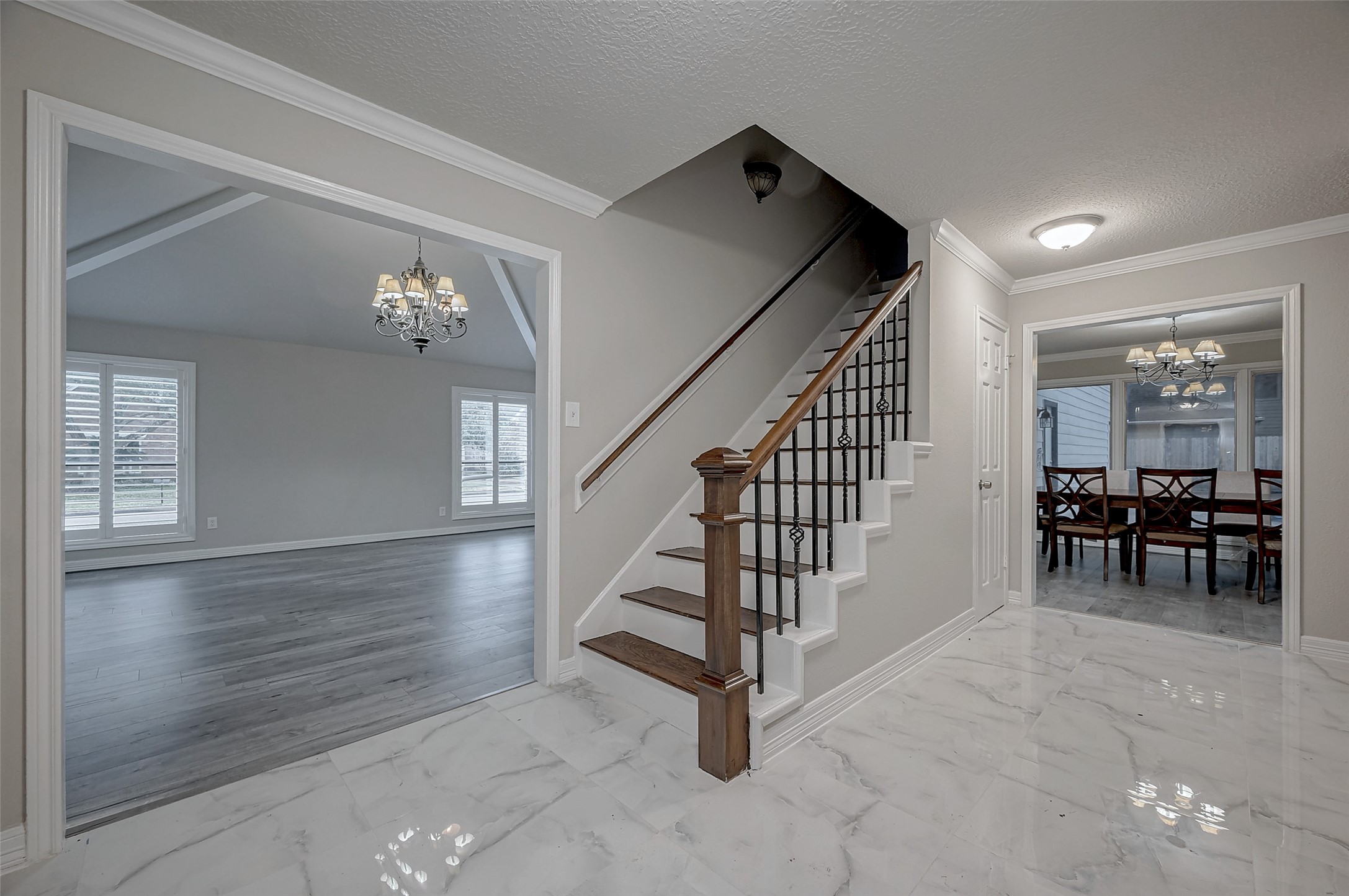 919 Mockingbird Way Sugar Land, TX 77478 - Photo 3 of 41 Entryway features marble floors and a staircase with elegant wooden and iron details.