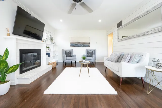 a living room with furniture a flat screen tv and a fireplace