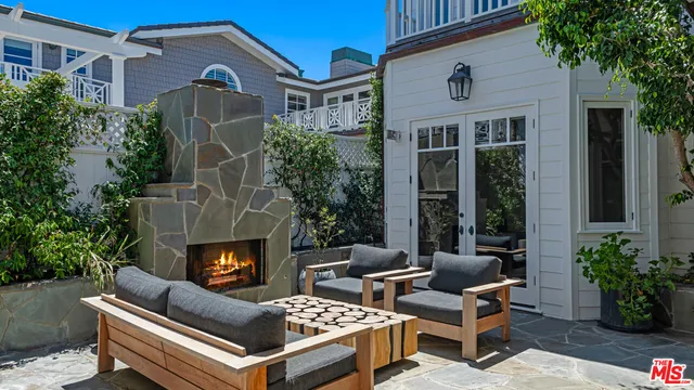 a view of a patio with couches and a fireplace