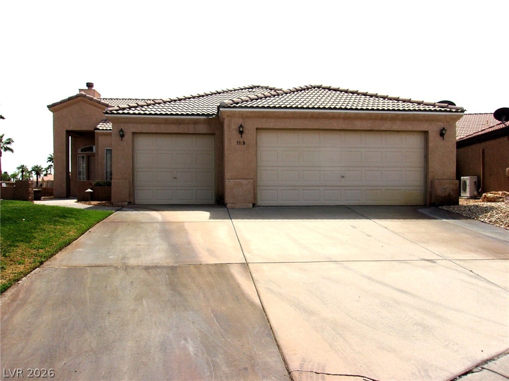 1160 Golf Club Drive Laughlin, NV 89029 - Photo 1 of 15 View of front of house featuring stucco siding, an attached garage, a tiled roof, and concrete driveway