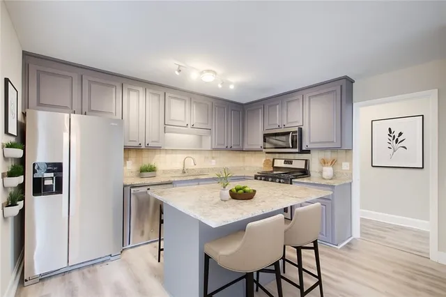 a kitchen with a refrigerator a stove a sink a stove a dining table and chairs