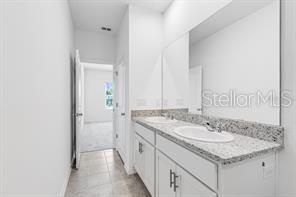 2995 Skyline Loop Kissimmee, FL 34758 - Photo 27 of 46 a bathroom with a granite countertop sink and a mirror