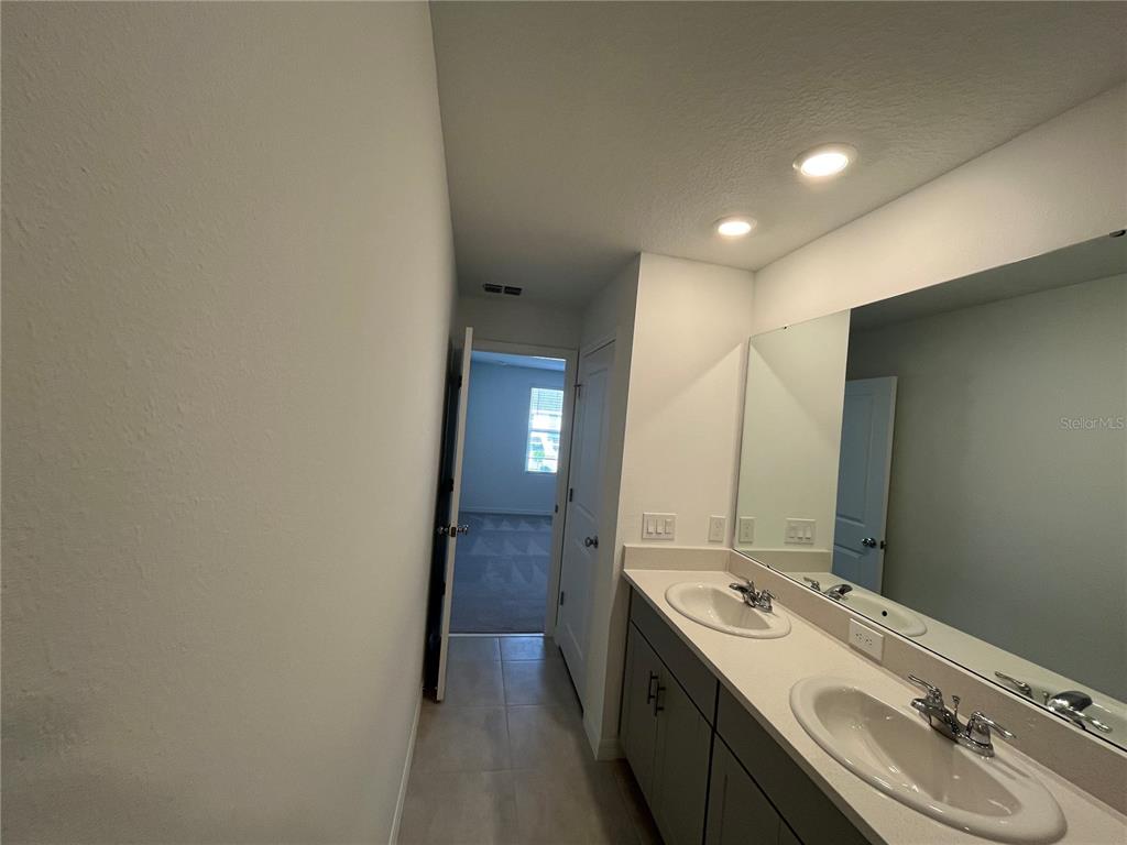2995 Skyline Loop Kissimmee, FL 34758 - Photo 28 of 46 a bathroom with a double vanity sink and mirror