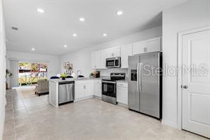 2995 Skyline Loop Kissimmee, FL 34758 - Photo 3 of 46 a kitchen with cabinets and stainless steel appliances