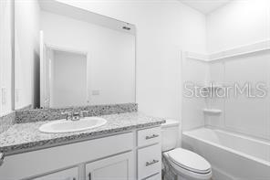 2995 Skyline Loop Kissimmee, FL 34758 - Photo 33 of 46 a bathroom with a granite countertop sink a toilet and bathtub