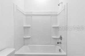 2995 Skyline Loop Kissimmee, FL 34758 - Photo 36 of 46 a bath room with a toilet and a bath tub