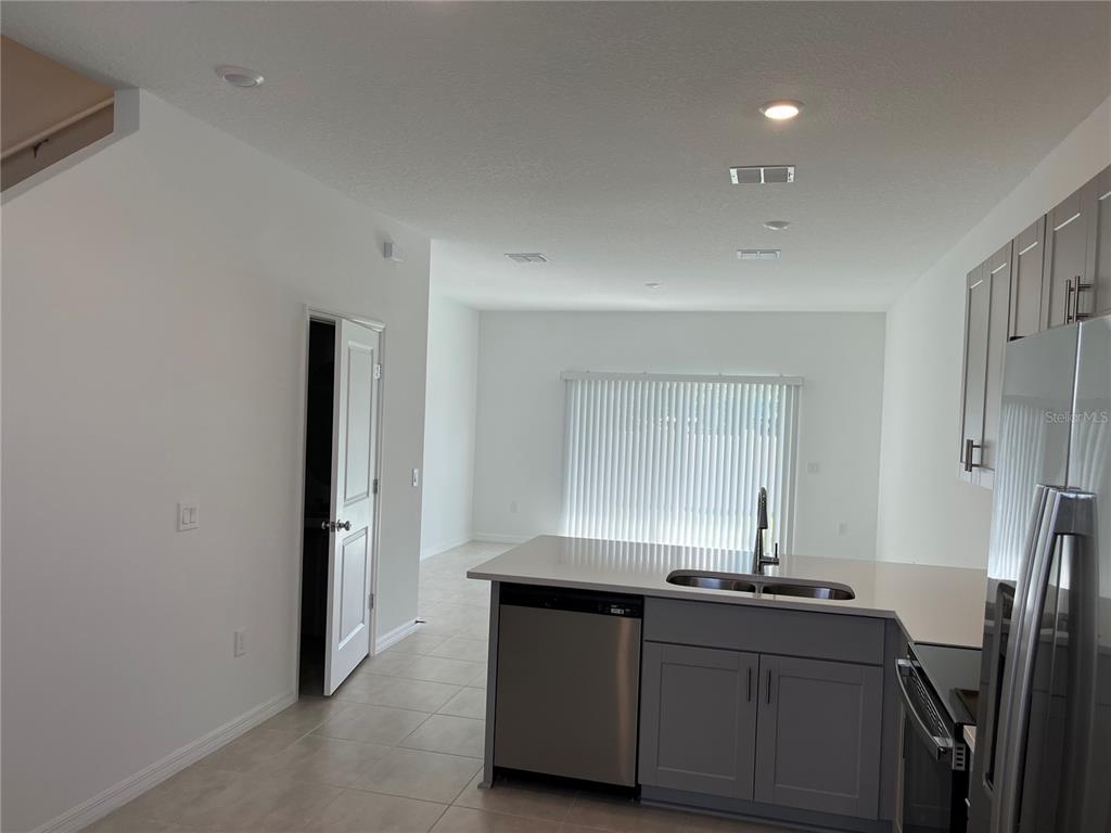2995 Skyline Loop Kissimmee, FL 34758 - Photo 6 of 46 a kitchen with granite countertop a sink and a refrigerator