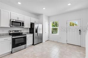 2995 Skyline Loop Kissimmee, FL 34758 - Photo 7 of 46 a kitchen with stainless steel appliances granite countertop a refrigerator a stove a microwave a sink and dishwasher