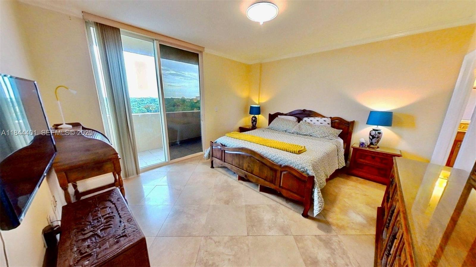 2425 Southwest 27th Avenue, Unit 701 Miami, FL 33145 - Photo 21 of 57 a bed sitting in a bedroom next to a window