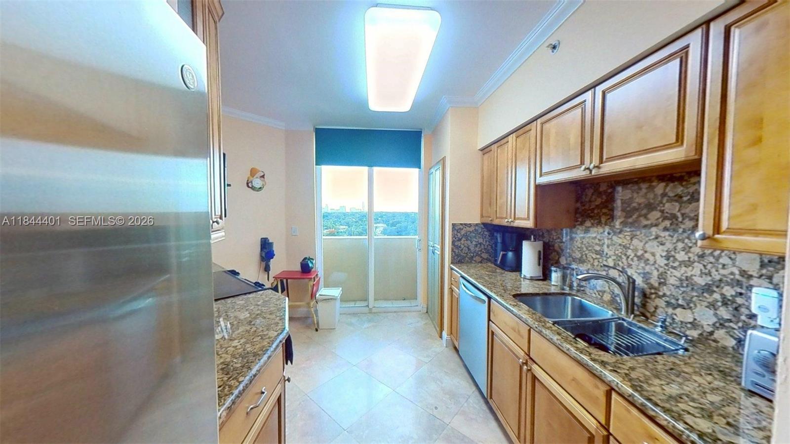2425 Southwest 27th Avenue, Unit 701 Miami, FL 33145 - Photo 29 of 49 a kitchen with stainless steel appliances granite countertop a sink stove and cabinets
