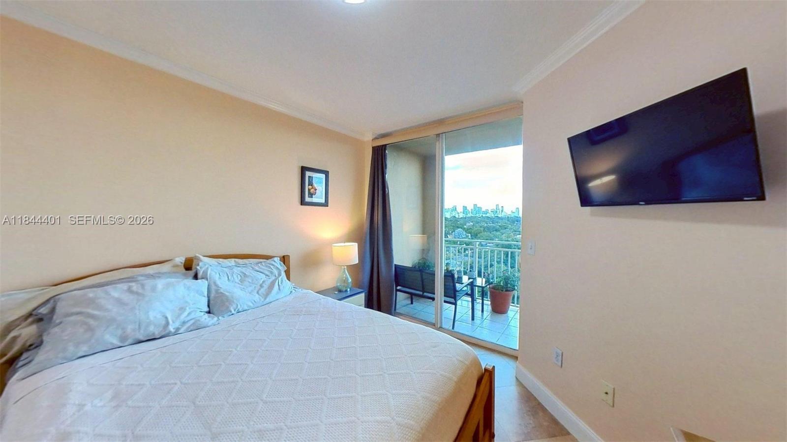 2425 Southwest 27th Avenue, Unit 701 Miami, FL 33145 - Photo 39 of 49 a bedroom with a bed and flat screen tv