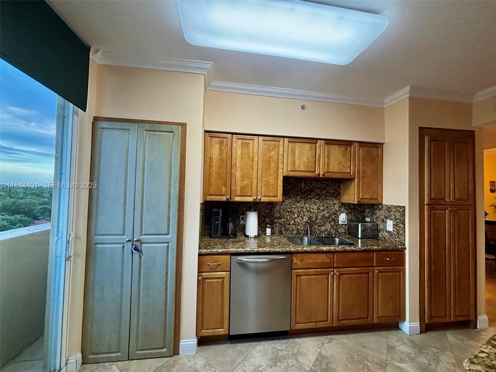 2425 Southwest 27th Avenue, Unit 701 Miami, FL 33145 - Photo 40 of 57 a kitchen with stainless steel appliances granite countertop a refrigerator and cabinets