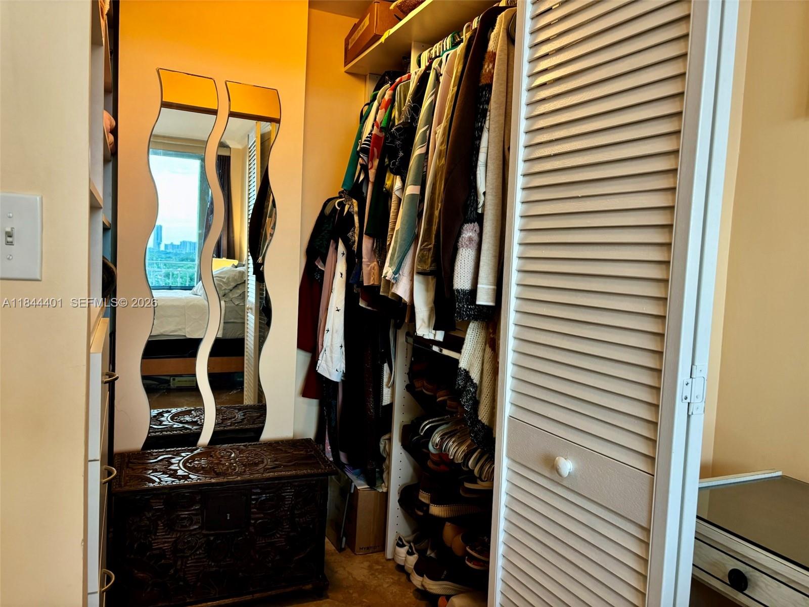 2425 Southwest 27th Avenue, Unit 701 Miami, FL 33145 - Photo 43 of 49 a view of walk in closet with clothes and shoes