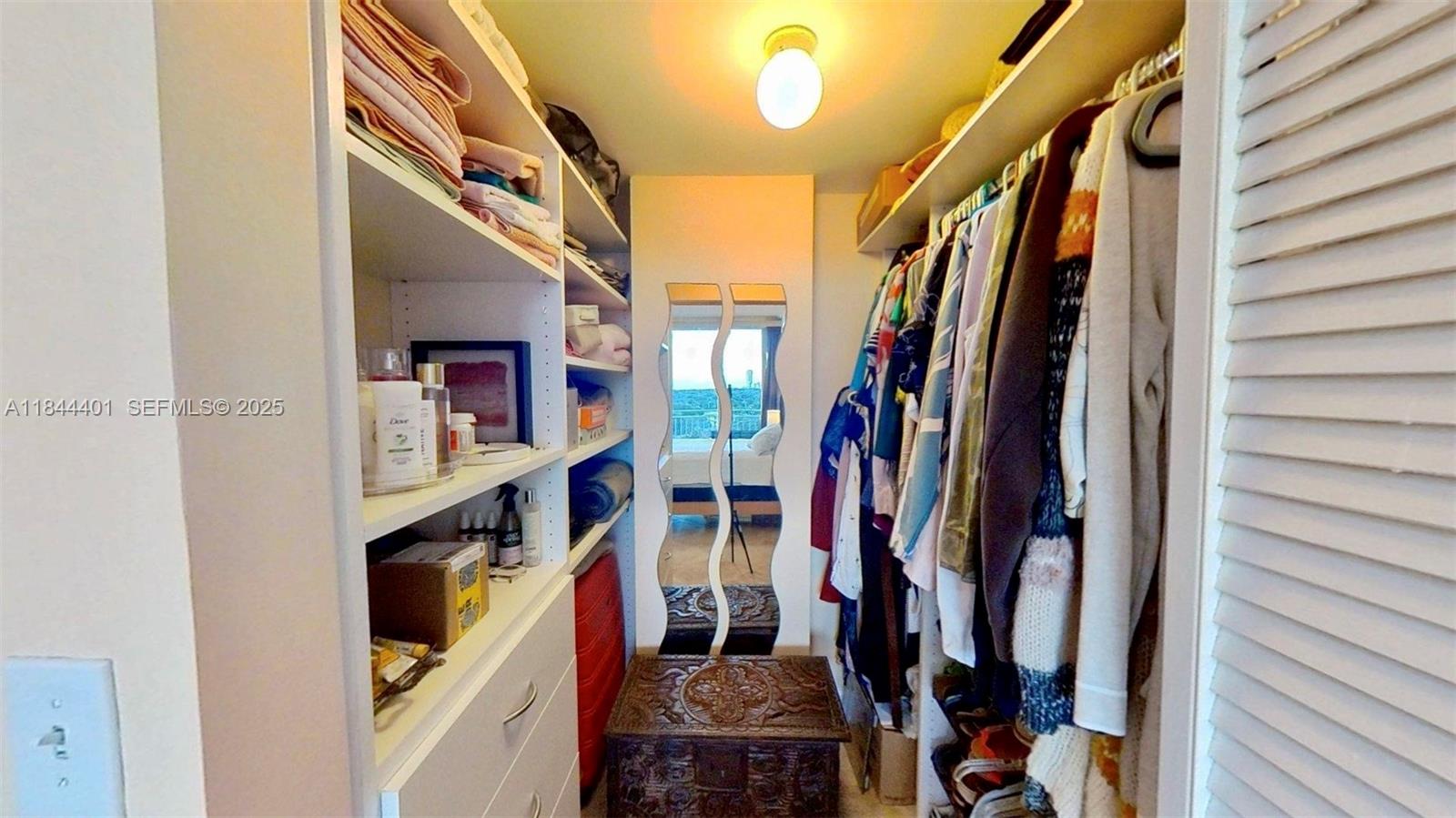 2425 Southwest 27th Avenue, Unit 701 Miami, FL 33145 - Photo 50 of 57 a view of walk in closet with clothes and shoes