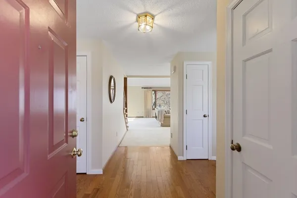 a view of a hallway with wooden floor and closet