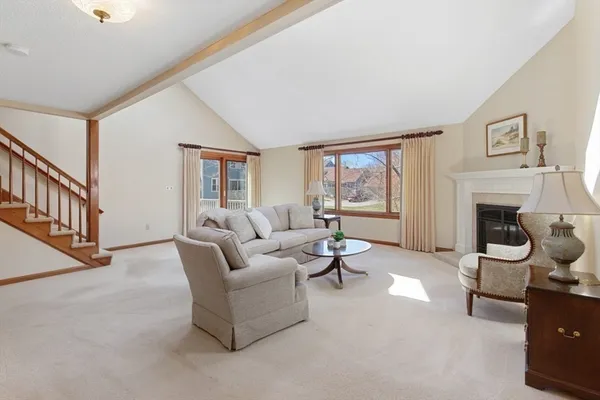 a living room with furniture a fireplace and a large window