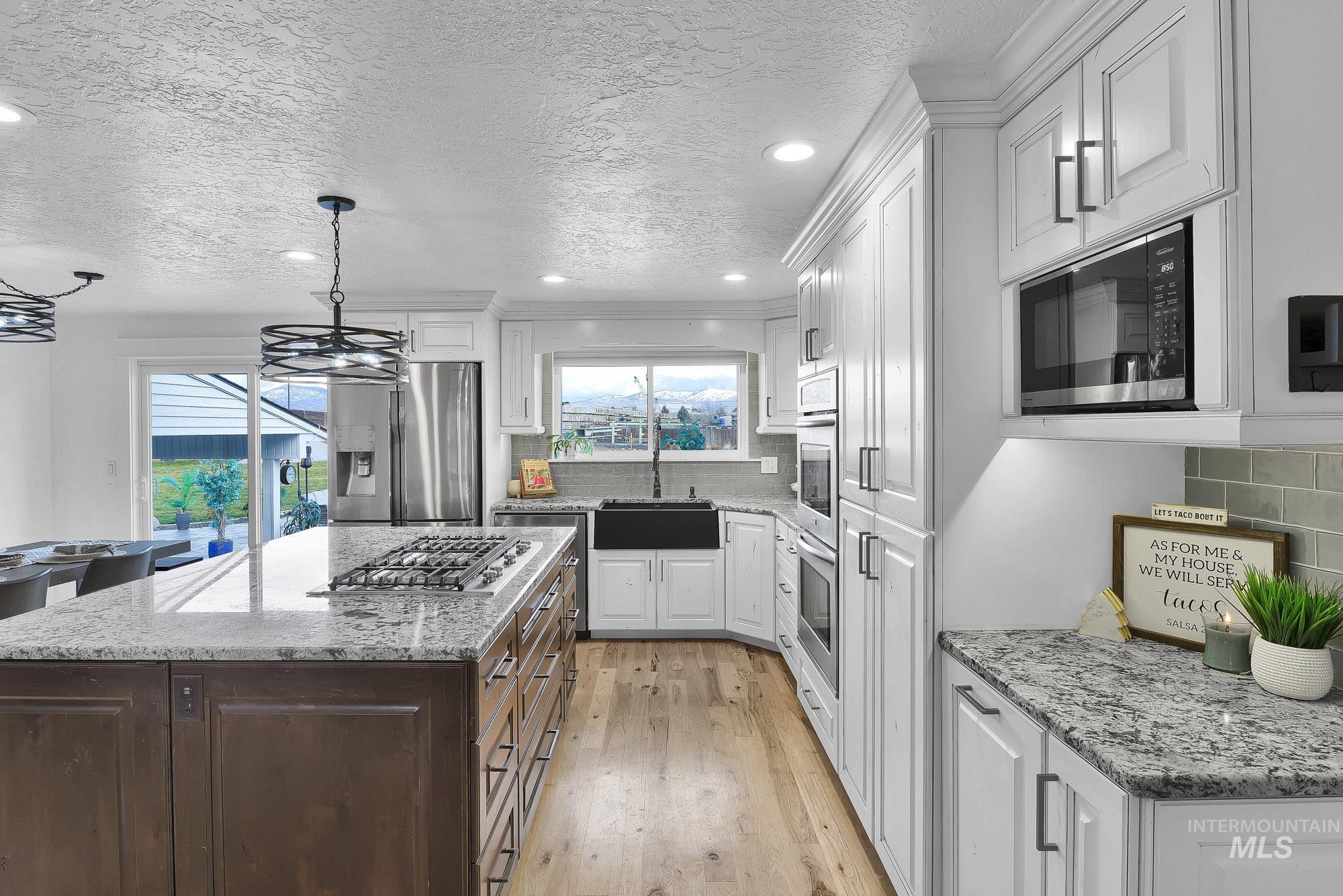 3630 Beverly Street Boise, ID 83709 - Photo 13 of 50 Kitchen with recessed lighting, backsplash, light stone counters, a textured ceiling, and appliances with stainless steel finishes