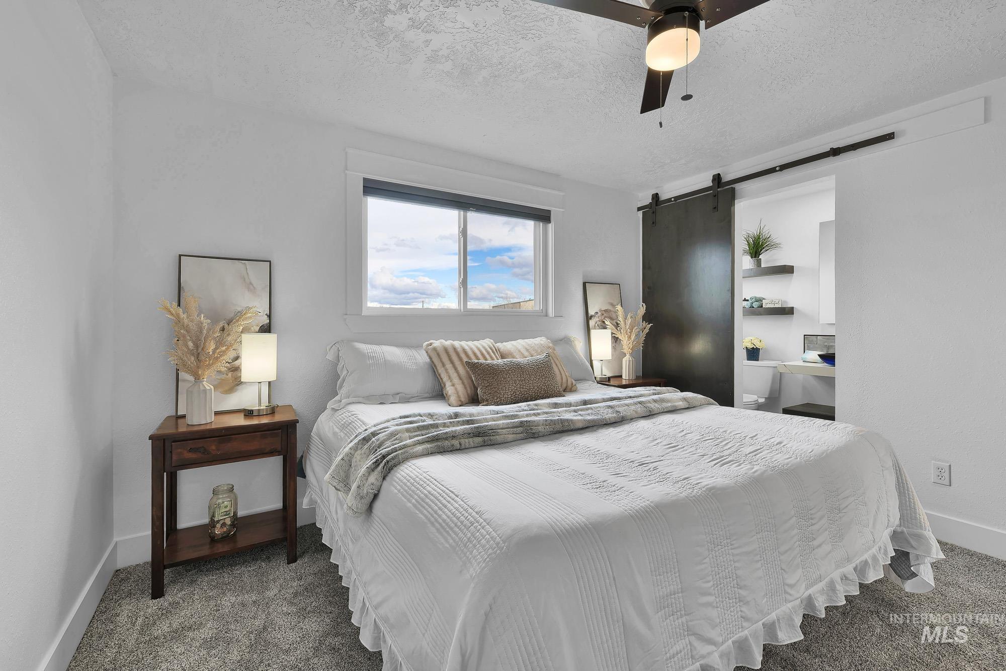 3630 Beverly Street Boise, ID 83709 - Photo 17 of 50 Bedroom with a barn door, a textured ceiling, carpet flooring, and a ceiling fan