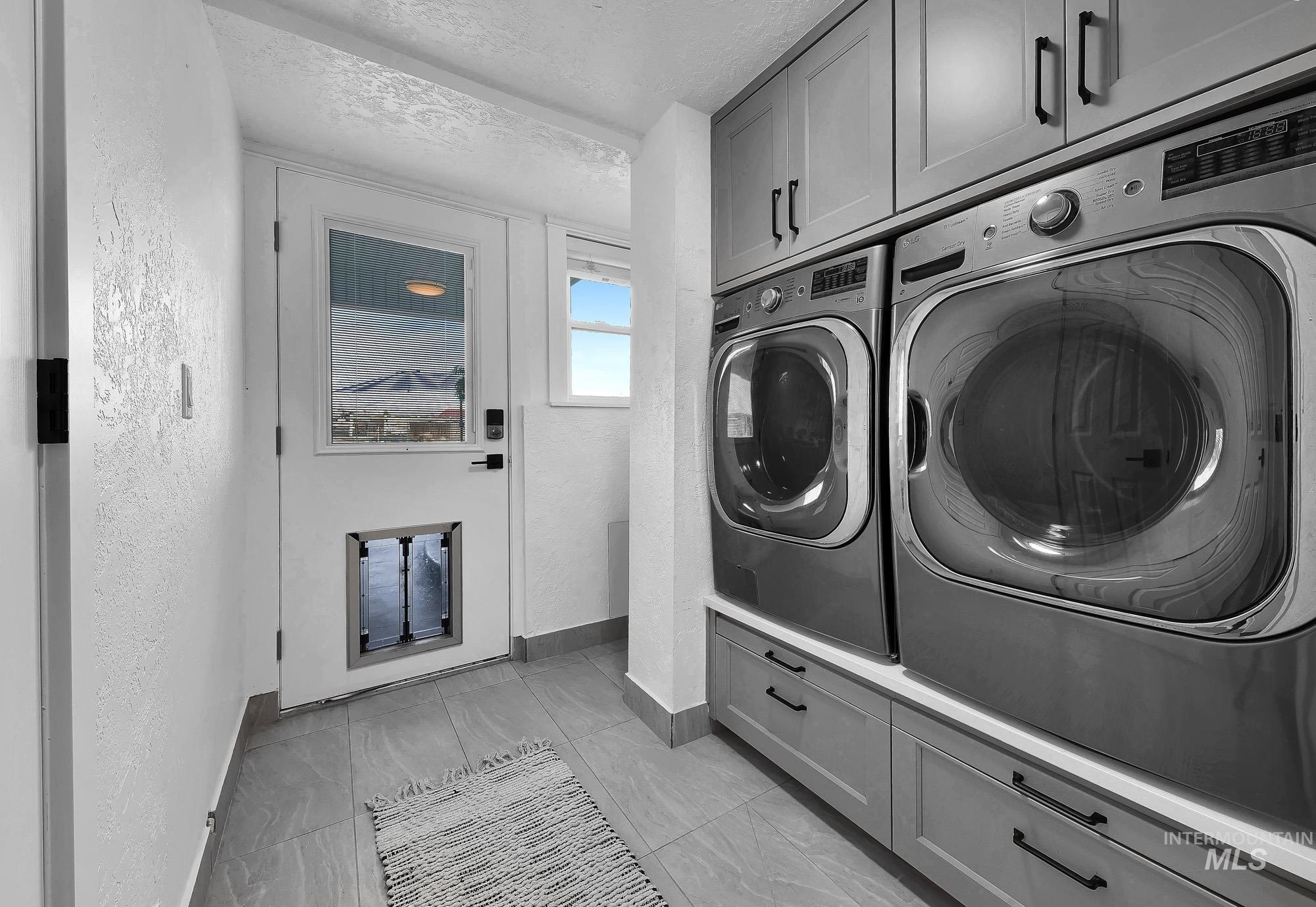 3630 Beverly Street Boise, ID 83709 - Photo 28 of 50 Laundry area featuring a textured ceiling, cabinet space, washer and clothes dryer, and light marble finish flooring