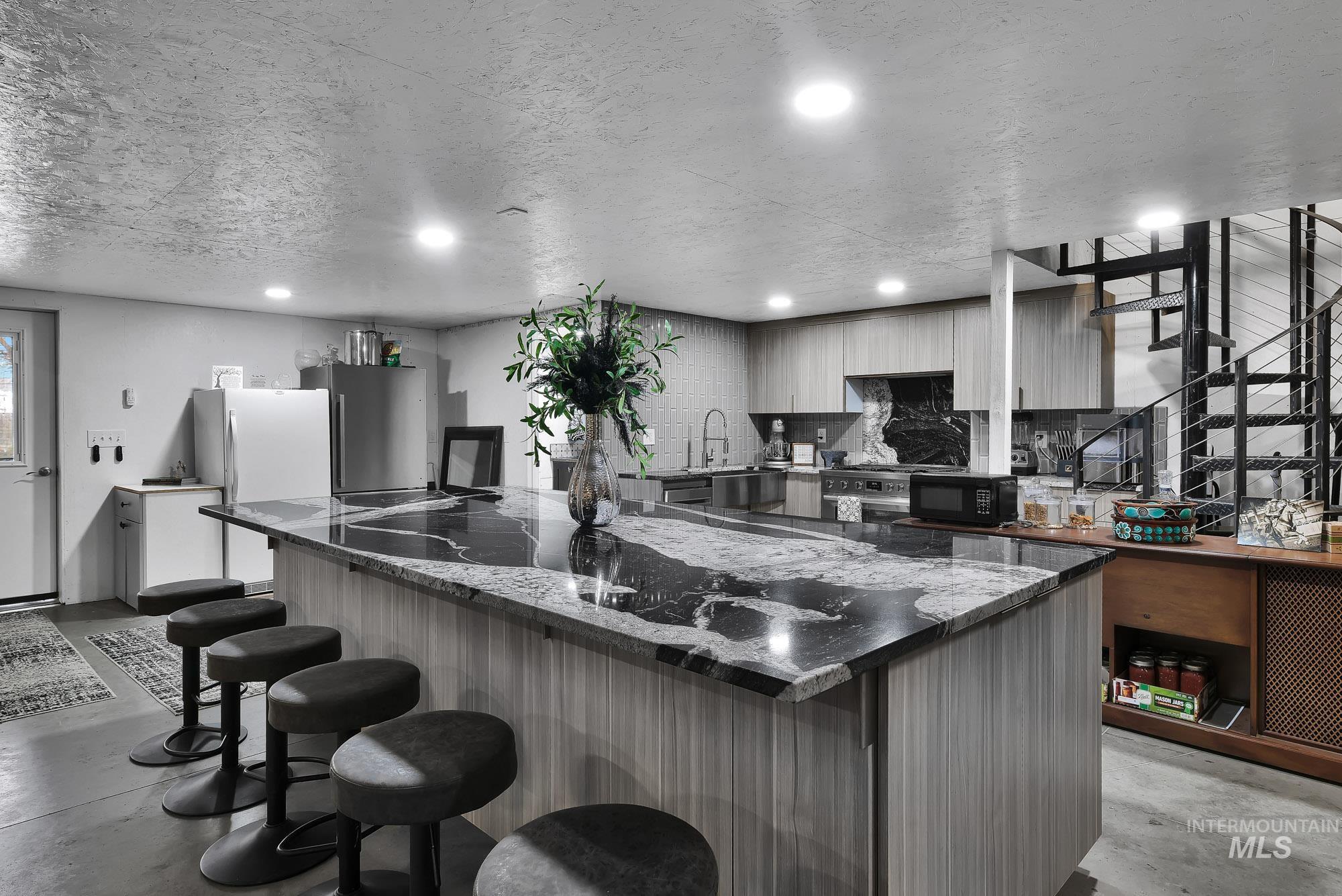 3630 Beverly Street Boise, ID 83709 - Photo 33 of 50 Kitchen featuring concrete floors, modern cabinets, a breakfast bar, a large island, and dark stone countertops