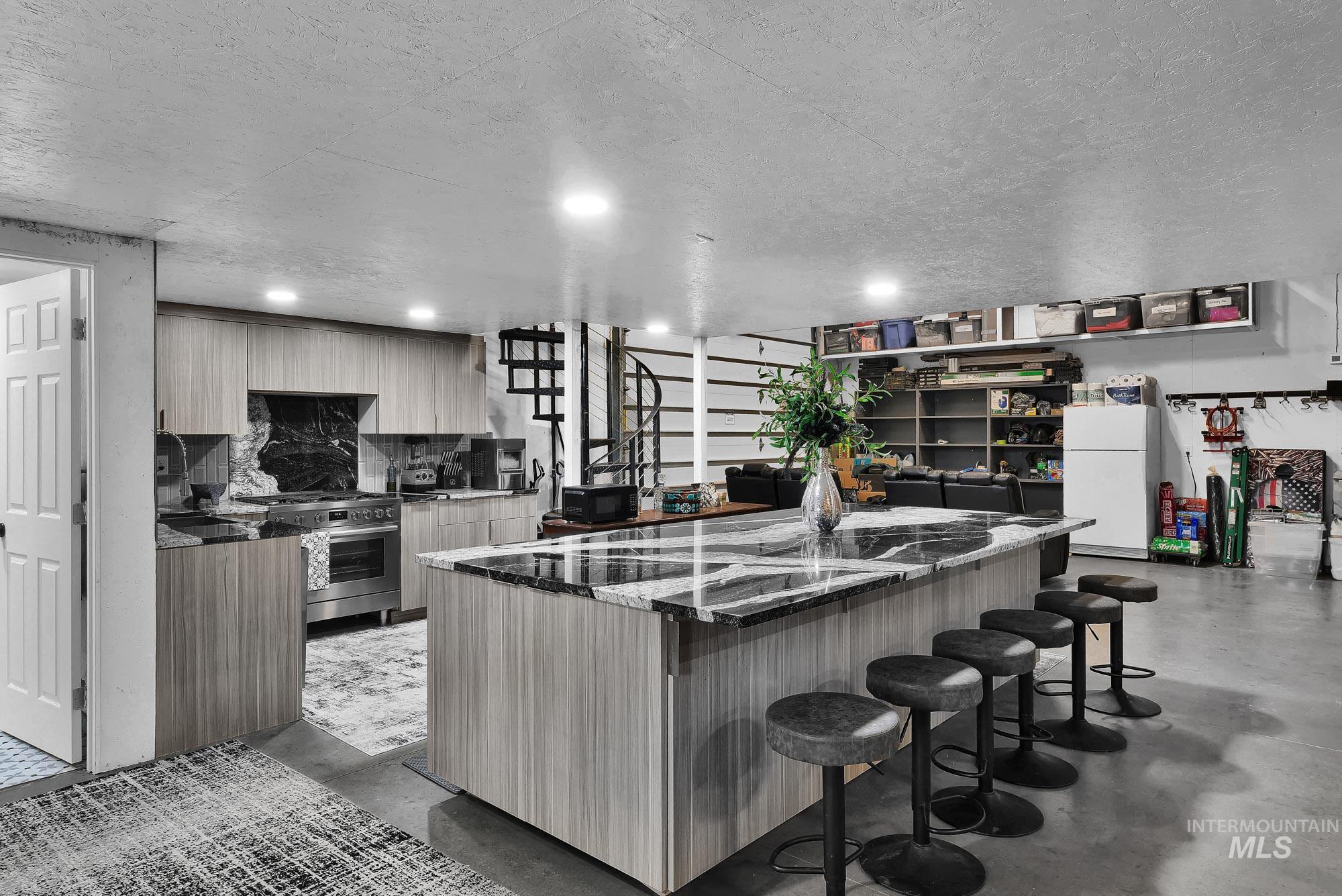 3630 Beverly Street Boise, ID 83709 - Photo 34 of 50 Kitchen featuring modern cabinets, finished concrete flooring, a kitchen breakfast bar, freestanding refrigerator, and recessed lighting