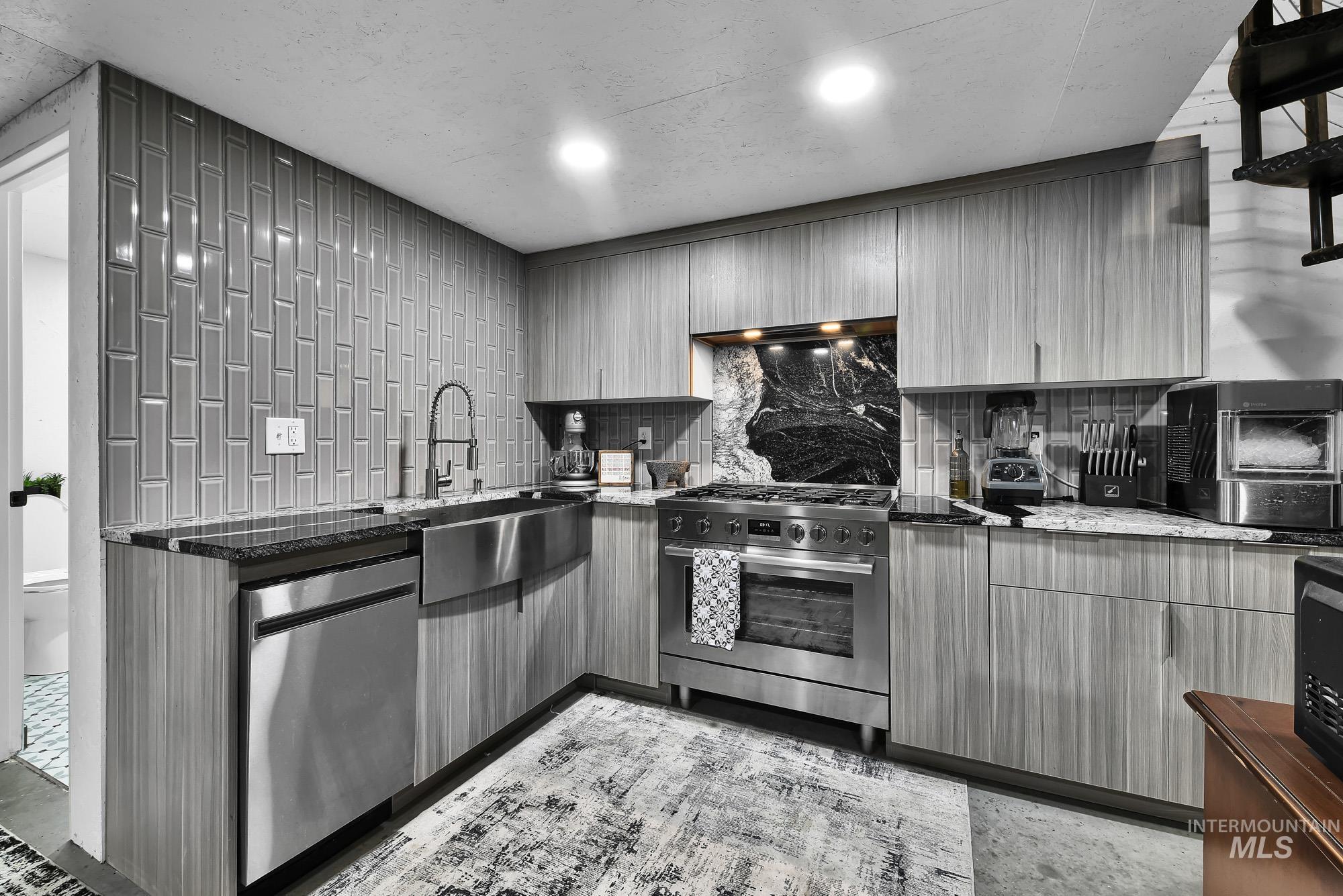 3630 Beverly Street Boise, ID 83709 - Photo 35 of 50 Kitchen with backsplash, dark stone countertops, stainless steel appliances, gray cabinetry, and modern cabinets