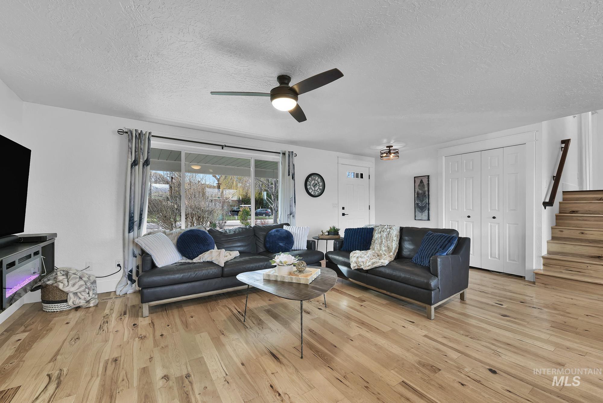 3630 Beverly Street Boise, ID 83709 - Photo 9 of 50 Living room with a textured ceiling, light wood-style floors, stairs, and ceiling fan
