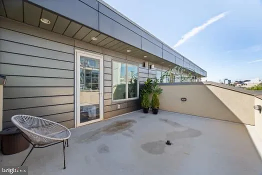 a view of a porch with furniture and floor to ceiling window