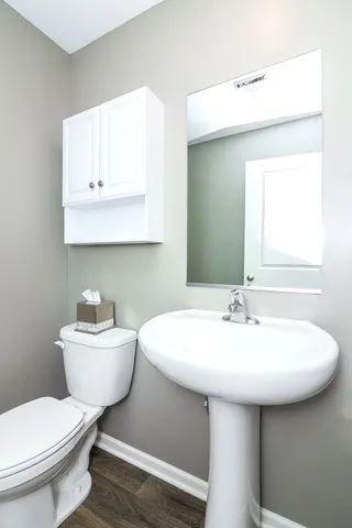 a bathroom with a toilet a sink and a mirror