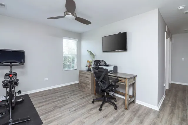 a view of a workspace with furniture and a window