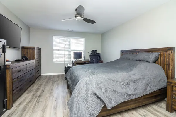 a bedroom with a bed and wooden floor