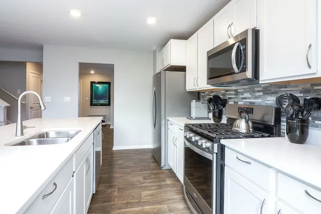a kitchen with stainless steel appliances granite countertop a sink stove and microwave