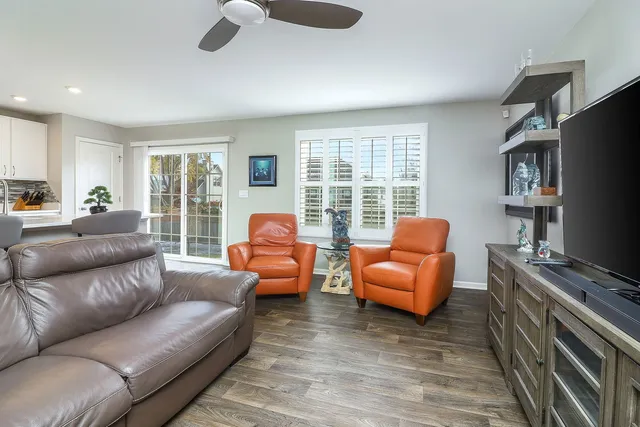 a living room with furniture a flat screen tv and a large window