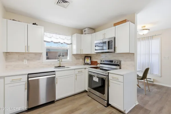 a kitchen with cabinets appliances a sink and a counter top space