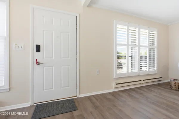 an empty room with wooden floor and windows