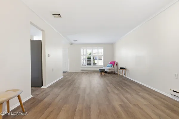 a view of a livingroom with wooden floor and white walls