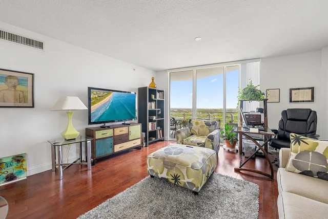 a spacious bedroom with a bed a couch and paintings on the wall