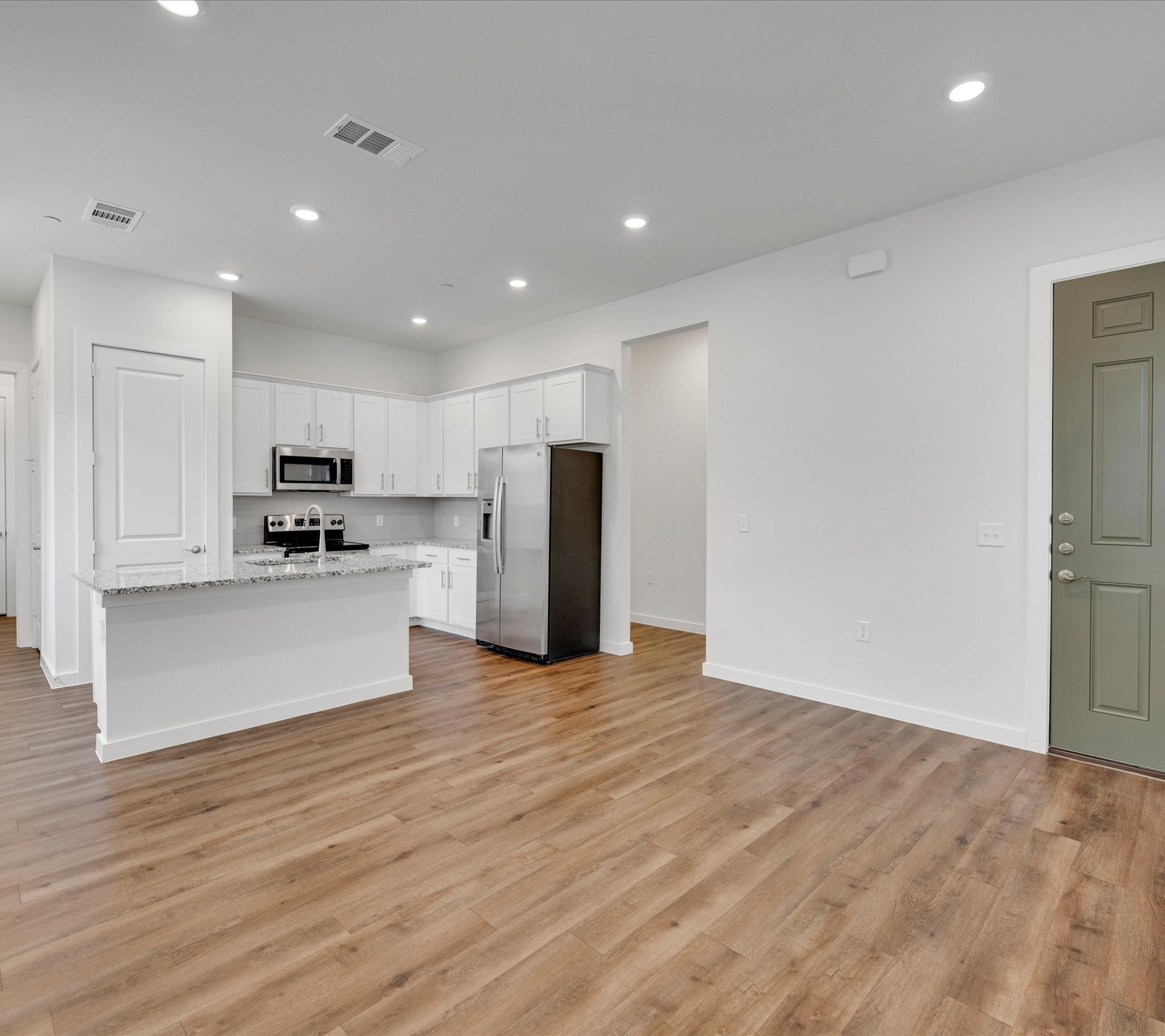 2709-602 Rockhill Road McKinney, TX 75072 - Photo 4 of 19 a view of kitchen with kitchen island wooden floor center island and stainless steel appliances