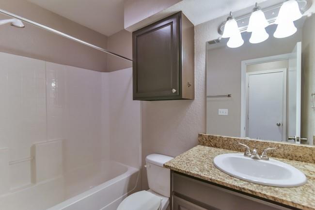 820 Southeast Parkway Azle, TX 76020 - Photo 6 of 9 a bathroom with a granite countertop sink a mirror and a bathtub
