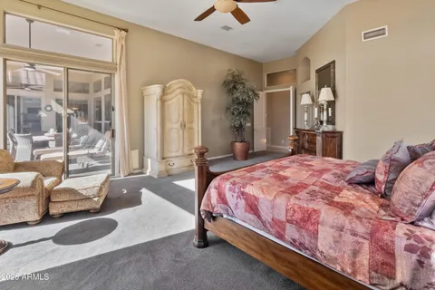 a bedroom with a bed couch and large window