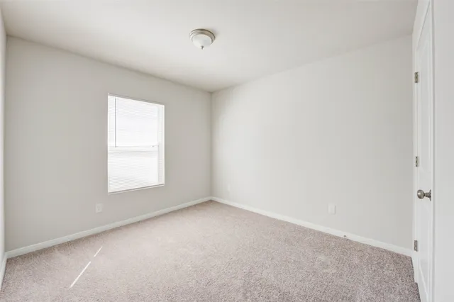 an empty room with a bathroom and mirror