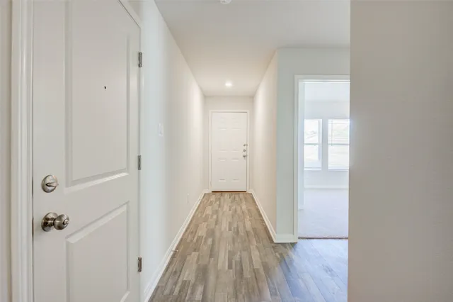 a view of a hallway with wooden floor and closet