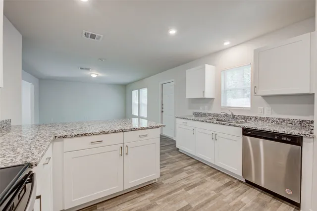 a kitchen with granite countertop white cabinets and white appliances