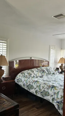 a view of a livingroom with wooden floor and a bathroom