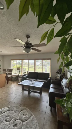 a living room with couches a flat screen tv and kitchen view
