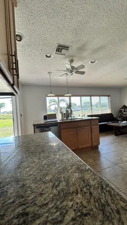 a kitchen with kitchen island granite countertop a sink counter top space appliances and a window