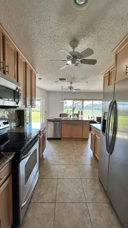 a kitchen with a refrigerator and white cabinets