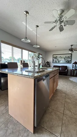 a kitchen with kitchen island granite countertop a sink counter top space appliances and a window