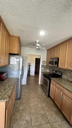 a living room with furniture a flat screen tv and kitchen view